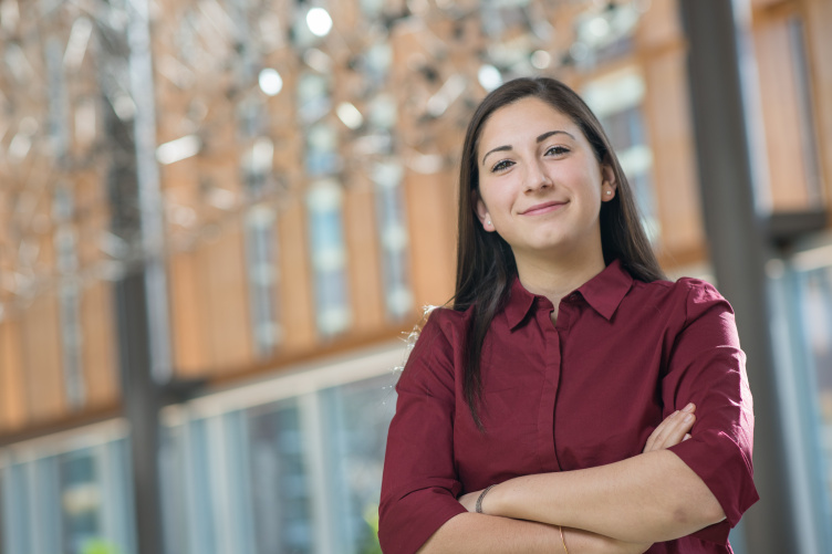 Janet Khoury '18 in Paul College's Great Hall UNH student stands confidently in UNH Paul College Great Hall