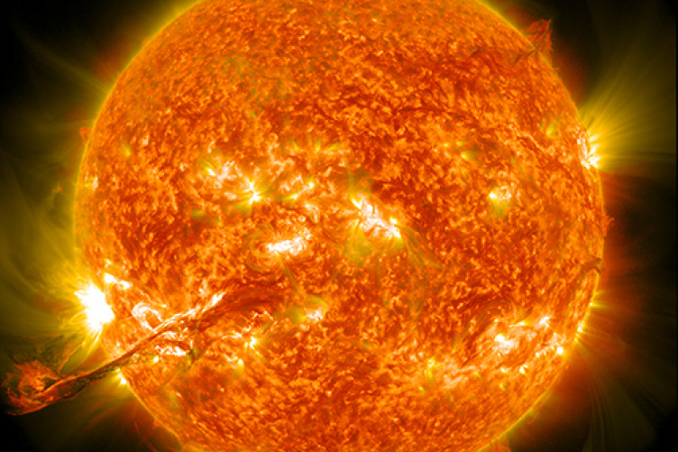 Close-up illustration of the sun with eruptions occurring on its surface. 