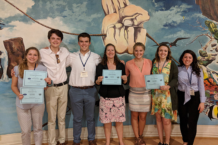 students and leader holding awards