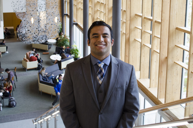 Hanzla Sheikh poses on the stairs of the Great Hall in Paul College