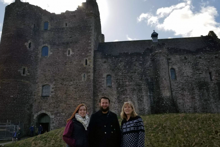 Two UNH students and a UNH alumna in front of a castle in Scotland