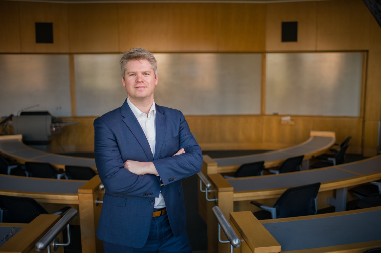 Professor Chris Glynn poses in a Paul College classroom