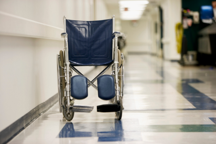 photo of wheelchair in empty hospital hallway