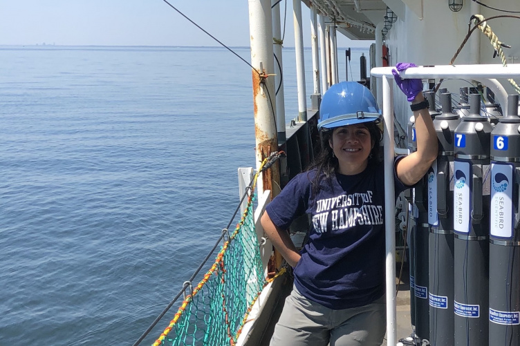 UNH grad student Melissa Melendez stands on the deck of a research vessel.
