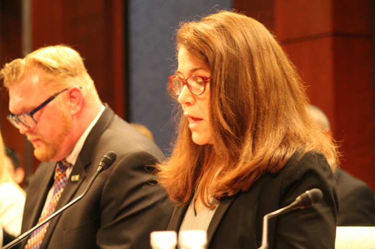 Sharyn Potter testifying before Congress with male in background