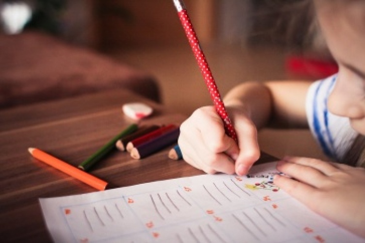 child writing on paper