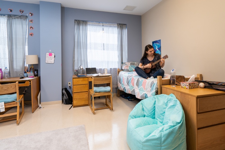 Student plays ukulele in UNH Downtown Commons dorm room