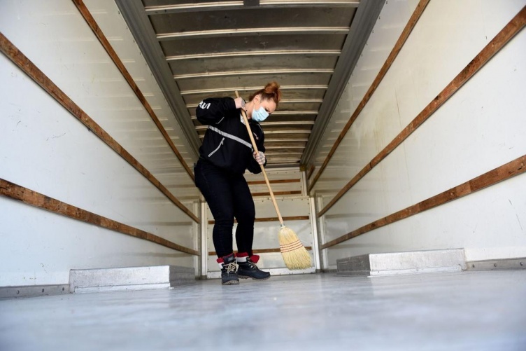Woman sweeps out a moving van