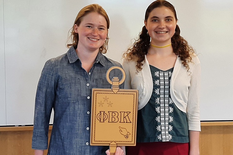 two students holding golden key