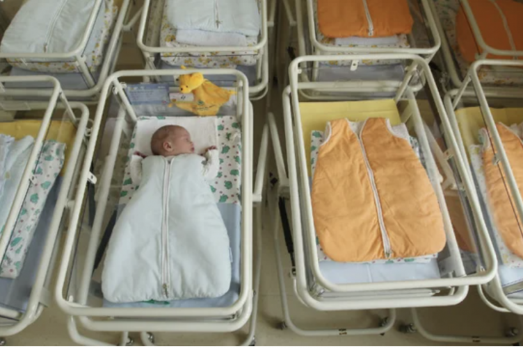 A photo showing two bassinets: one with a baby, one without a baby