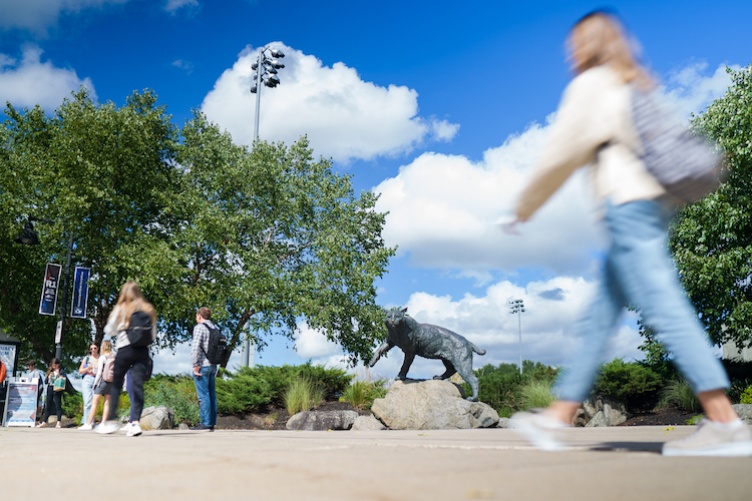 Students walking past the Wildcat statue