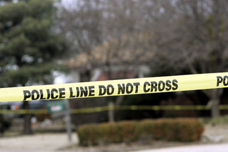 Yellow police tape blocks off entrance to a street.