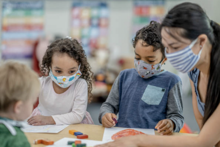 A teacher at a childcare center works with children