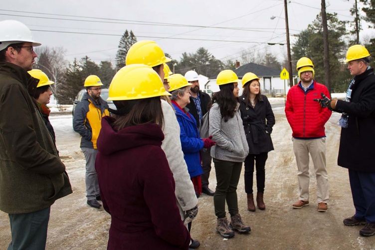 Several students speaking with a public servant during a field trip.