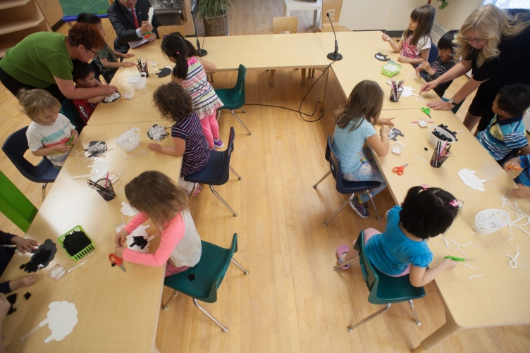 A photo showing a childcare provider's classroom filled with children and instructors