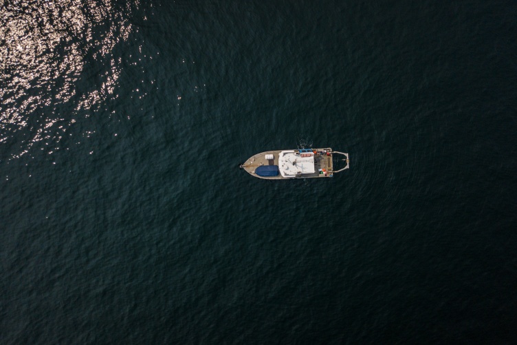 An aerial view of a ship on the calm ocean water.