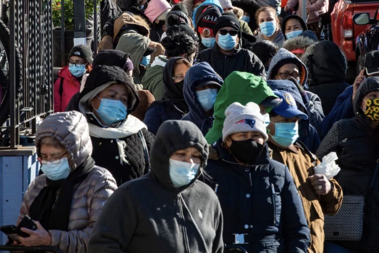 A photo showing a large group of people walking in a city