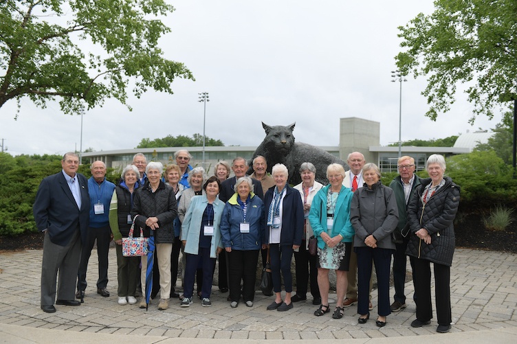 Group of alums gather around the Wildcat statue at reunion