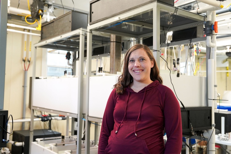 Marine scientist Brittany Jellison stands in front of a multi-stressor marine environment system recently installed at UNH’s Coastal Marine Lab in New Castle, NH.