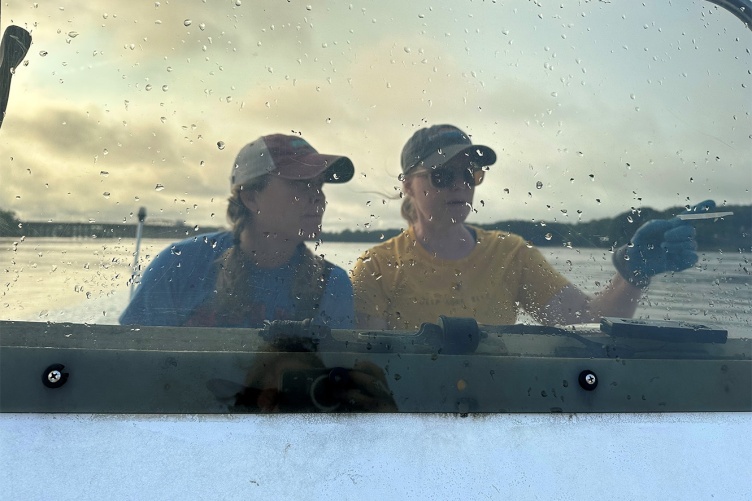 Sisters Krystin Ward, left, and Laura Brown navigate a boat from Great Bay Estuary toward the restoration site near Nannie Island.