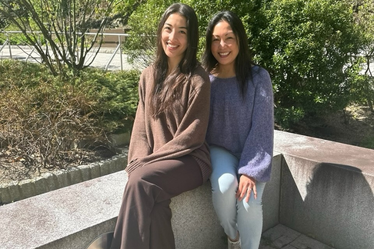 Leni and Michelle Lemos sit outside of the Peter T. Paul College of Business and Economics.