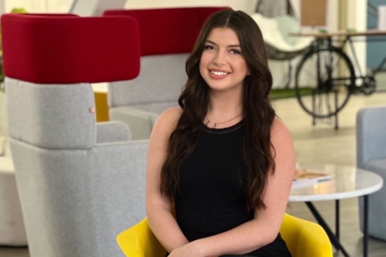 Cassaundra Kalba sits in a chair for a professional headshot.