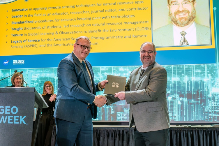 UNH professor Russ Congalton (right) is handed an award from Tim Glynn, Chief of Staff of the U.S. Geological Survey's Earth Resources and Observation Science (EROS) Center.