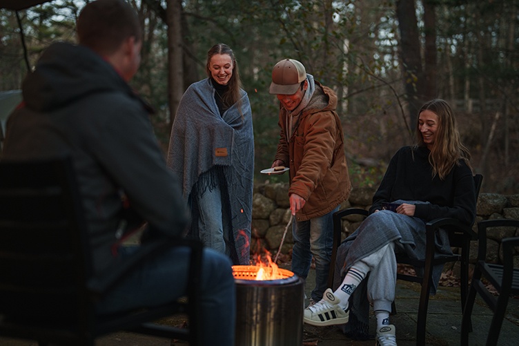 A group of students gather around a campfire