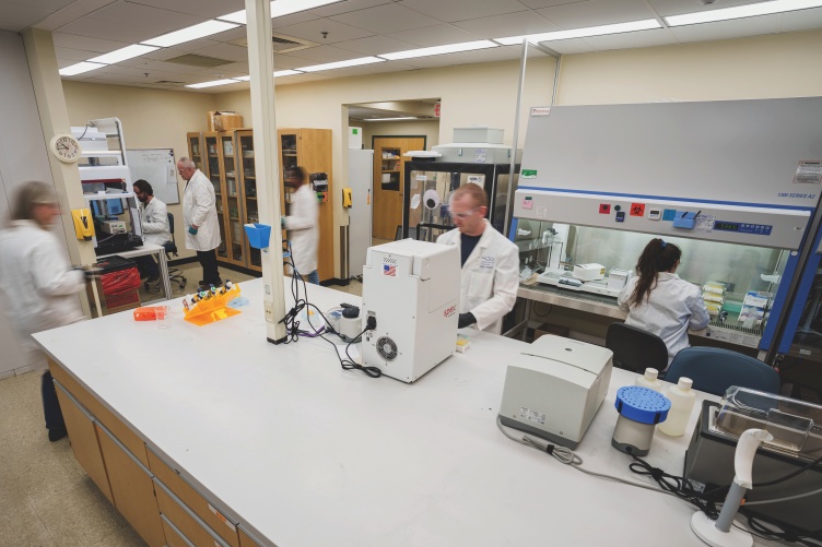 A wide shot of a lab, with several people working