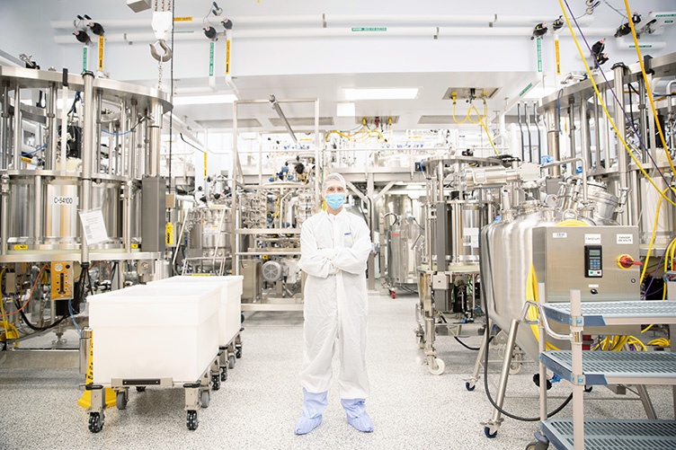 Man wearing white protective suit standing in the middle of laboratory space