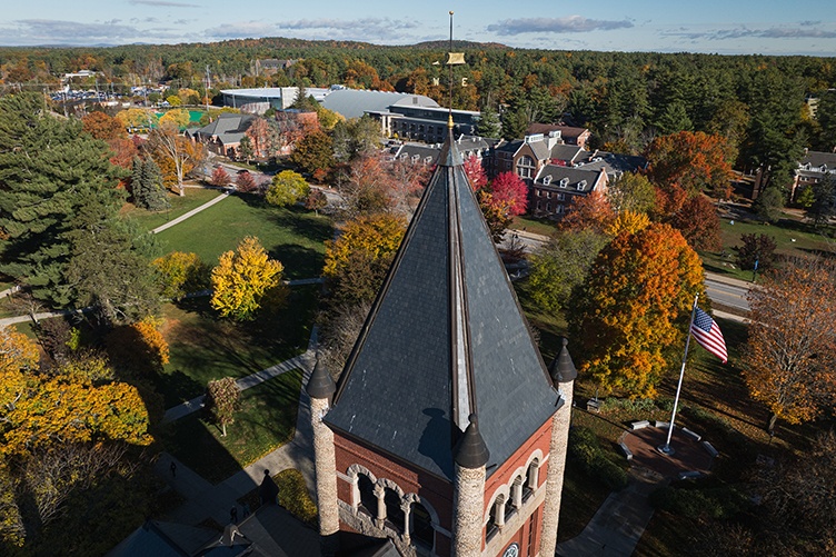 Aerial view of Thompson Hall tower with colorful fall trees and campus buildings in the background