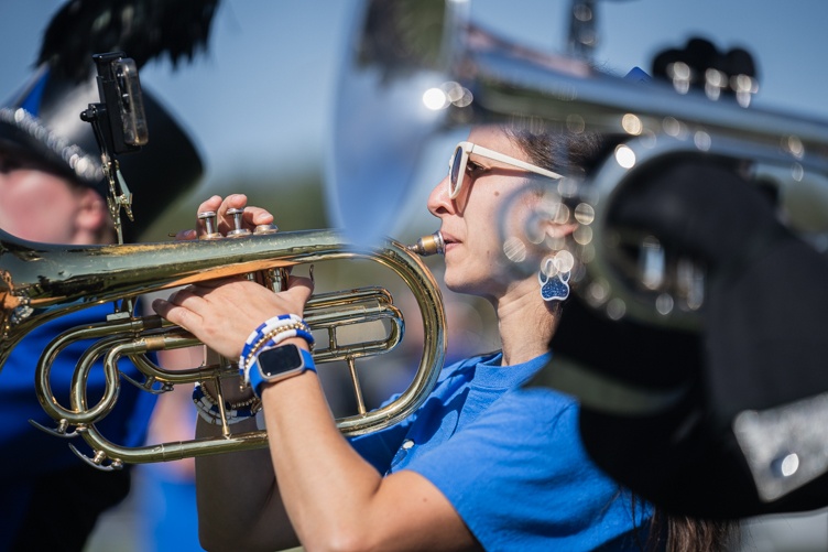 A member of the UNH marching band plays a brass instrument