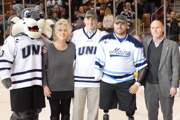 Ryan Pitts, Travis Mills, Wild-Ecat, and supporters on ice.