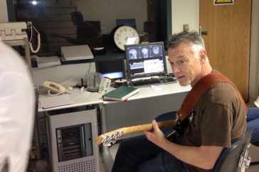 Professor Don Robin playing the guitar while subject undergoes brain scan.