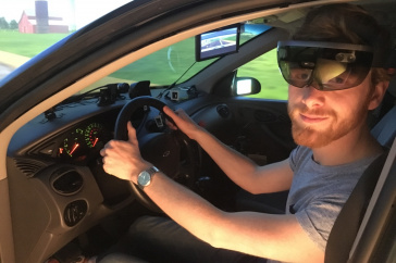 Man sitting in a driving simulator wearing augmeted reality goggles