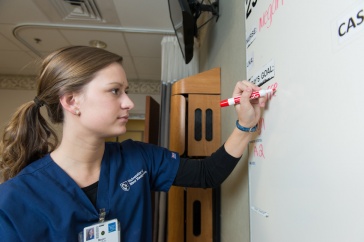 nursing student working on white board