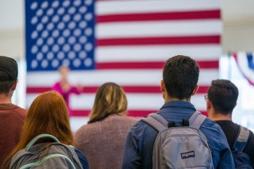 students in front of an American flag