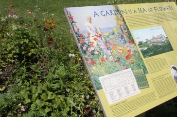 Sign with text in front of bright garden flowers