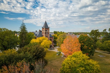 Aerial photo of UNH campus in fall, with bright trees in front of T Hall