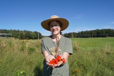 Student holding peppers in a field