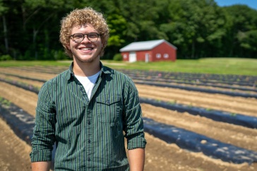 Eliudes Camps Marcano, an exchange student from Puerto Rico, stands in a field at the Kingman Research Farm, where he helped support agricultural research at UNH this past summer.