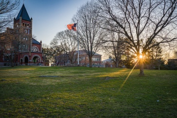 Thompson Hall at sunrise, with flag 