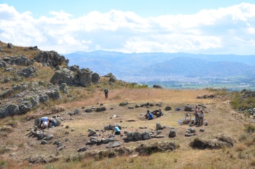 From a distance we see a circle of stones on a mountainside.