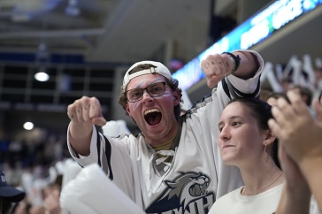 Male student cheering in a crowd at a hockey game