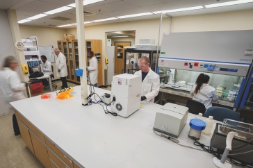 A wide shot of a lab, with several people working