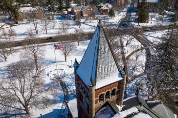 Aerial view of brick clock tower with dusting of snow on top