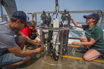 UNH students take water quality samples in the Gulf of Maine from aboard a boat.