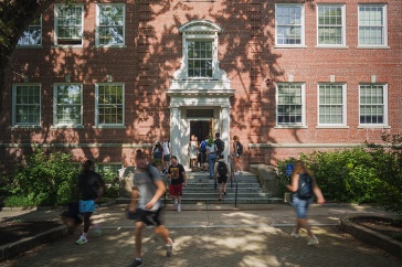 time lapse of students walking into and out of a brick academic building