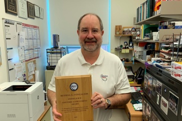 Professor Russ Congalton holding up his AmericaView Lifetime Achievement Award