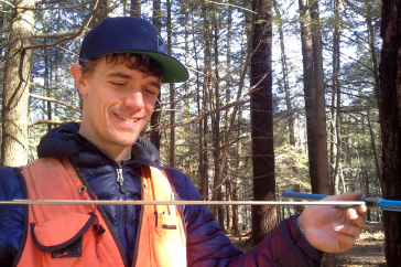 Cameron McIntire, a doctoral student in natural resources and the environment at UNH, cores an eastern white pine